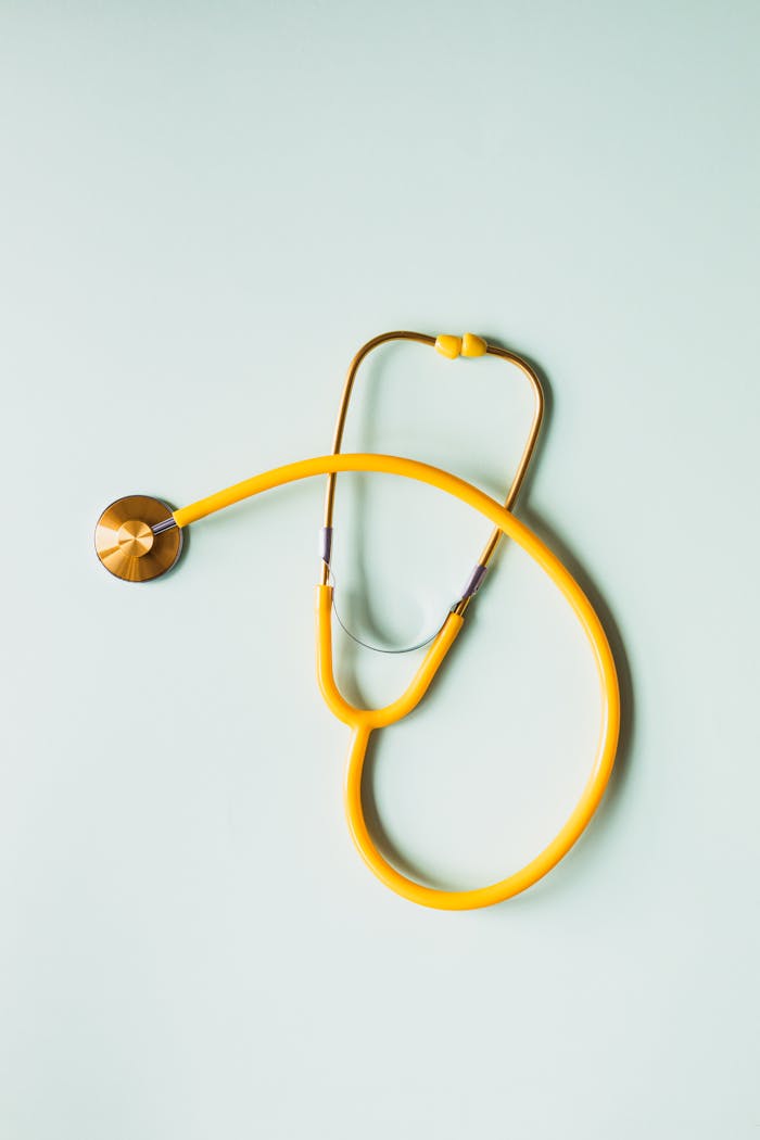 digital Top view of yellow medical stethoscope placed on white surface during coronavirus pandemic
