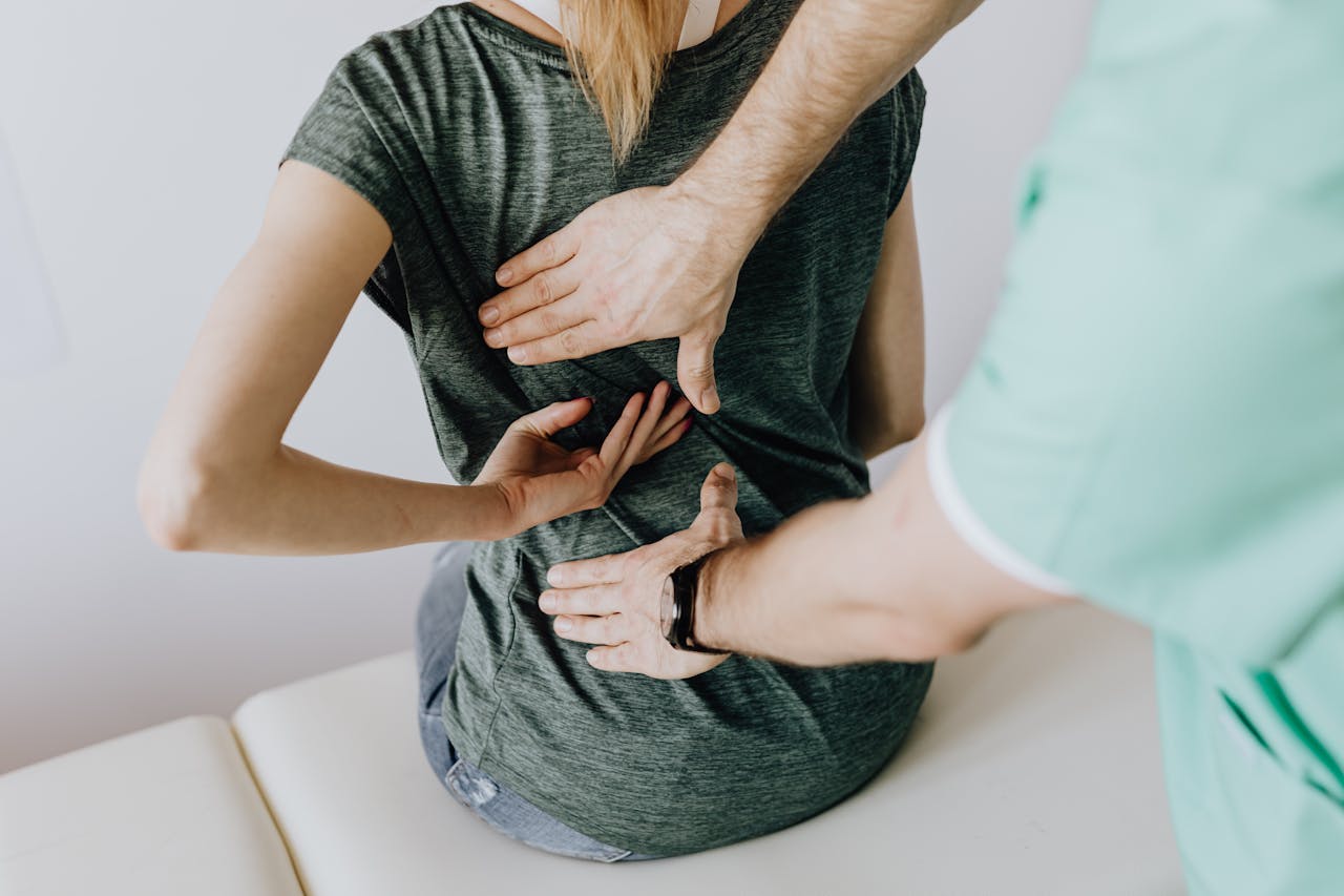 why-choose-us A chiropractor examining a patient's back to alleviate pain and discomfort.
